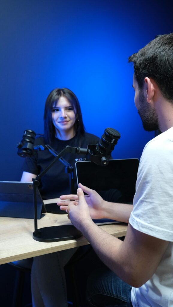 Two adults in a studio recording a podcast with professional equipment.
