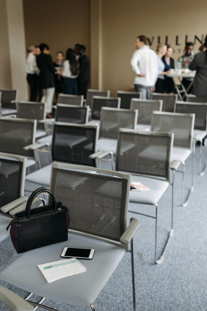 A modern conference room with empty chairs and abandoned personal items in the foreground.